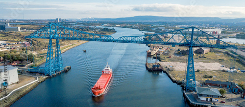 Obraz na płótnie Tees Transporter Bridge with a large ship sailing under the bridge w salonie