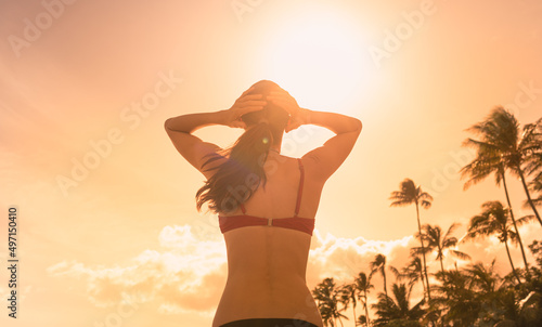 Happy woman on a beach looking up to the sunny sky feeling free in nature 