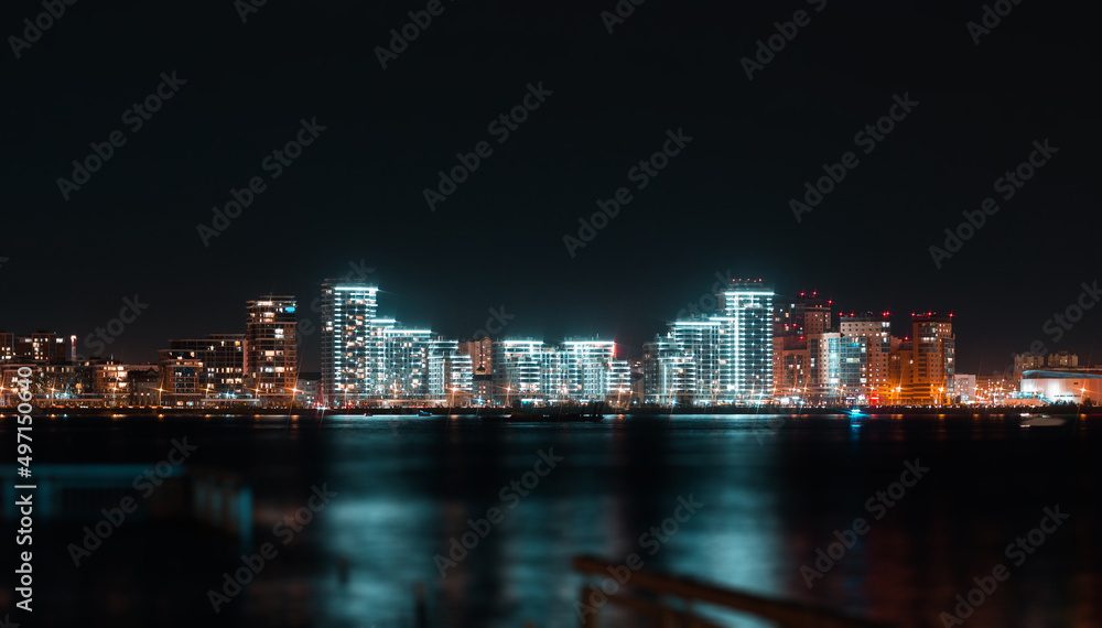 Naklejka premium Panoramic view of Kazan city waterfront illuminated skyscrapers. New residential neighborhoods on the river bank in Kazan