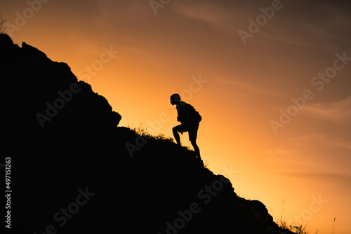 Goal setting. Silhouette of man climbing up mountain