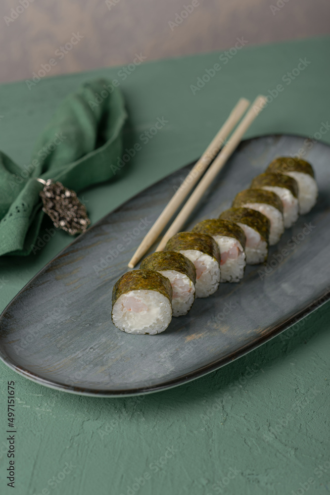 Close-up view of process of preparing rolling sushi. making the sushi with sauce and sesame seeds, pours delicious fresh rolls with a sauce. Close-up view of process of preparing rolling sushi. making the sushi with sauce and sesame seeds, pours delicious fresh rolls with a sauce.