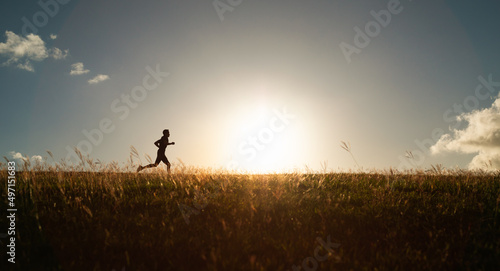 Man running jogging across a field early morning 