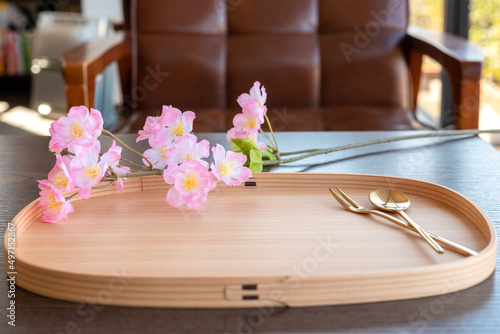 まげわっぱ盆に乗ったゴールドのカトラリー スプーンとフォーク 桜の花 カフェの椅子 