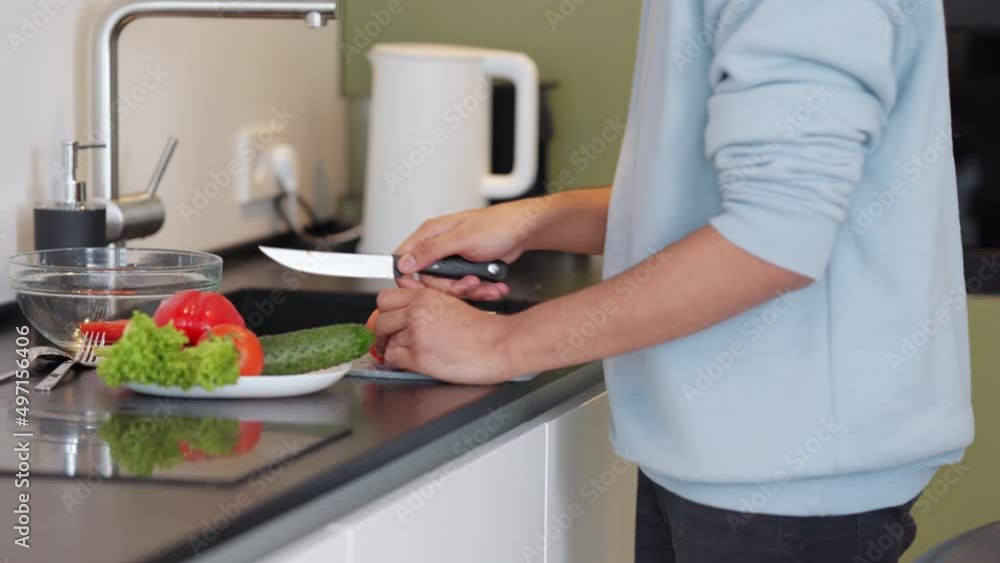 Man wearing sweatshirt cooking salad at home Man wearing sweatshirt cooking salad at home