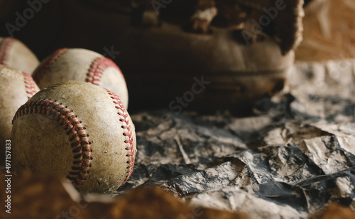 Vintage retro baseball background with used balls and glove closeup.