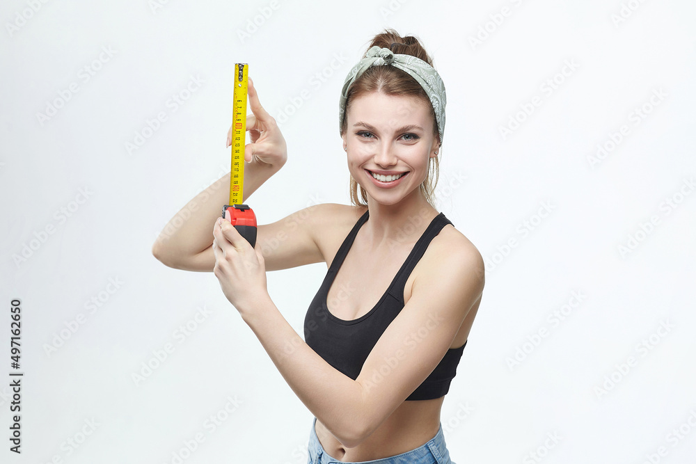 beautiful blonde girl holds a measuring tape in her hands. measurement concept about penis size beautiful blonde girl holds a measuring tape in her hands. measurement concept about penis size