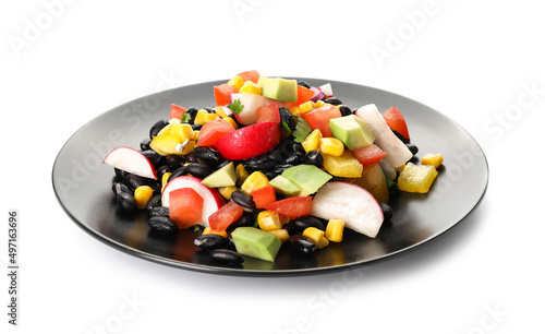 Plate of delicious Mexican vegetable salad with black beans and radish on white background