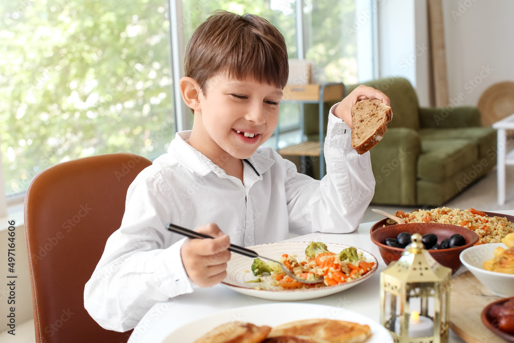 Muslim little boy having breakfast. Celebration of Eid al-Fitr Muslim little boy having breakfast. Celebration of Eid al-Fitr