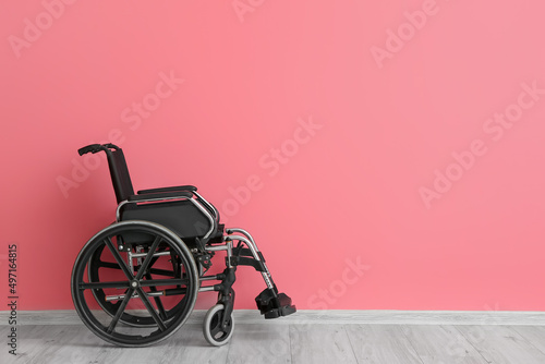 Empty wheelchair near color wall photo