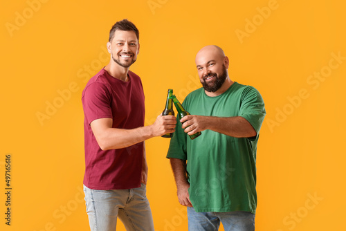 Men drinking beer on yellow...