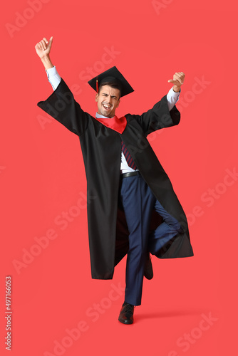 Young male graduate dancing...