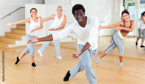 Positive aframerican man enjoying active dances in modern dance studio.