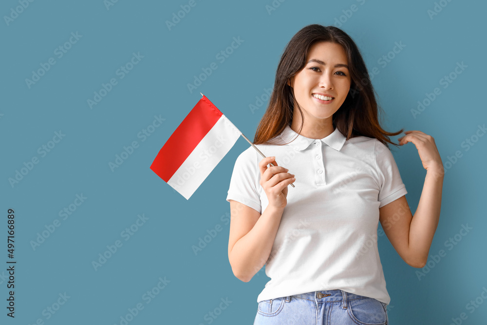 Young Asian woman with flag of Indonesia on blue background Young Asian woman with flag of Indonesia on blue background
