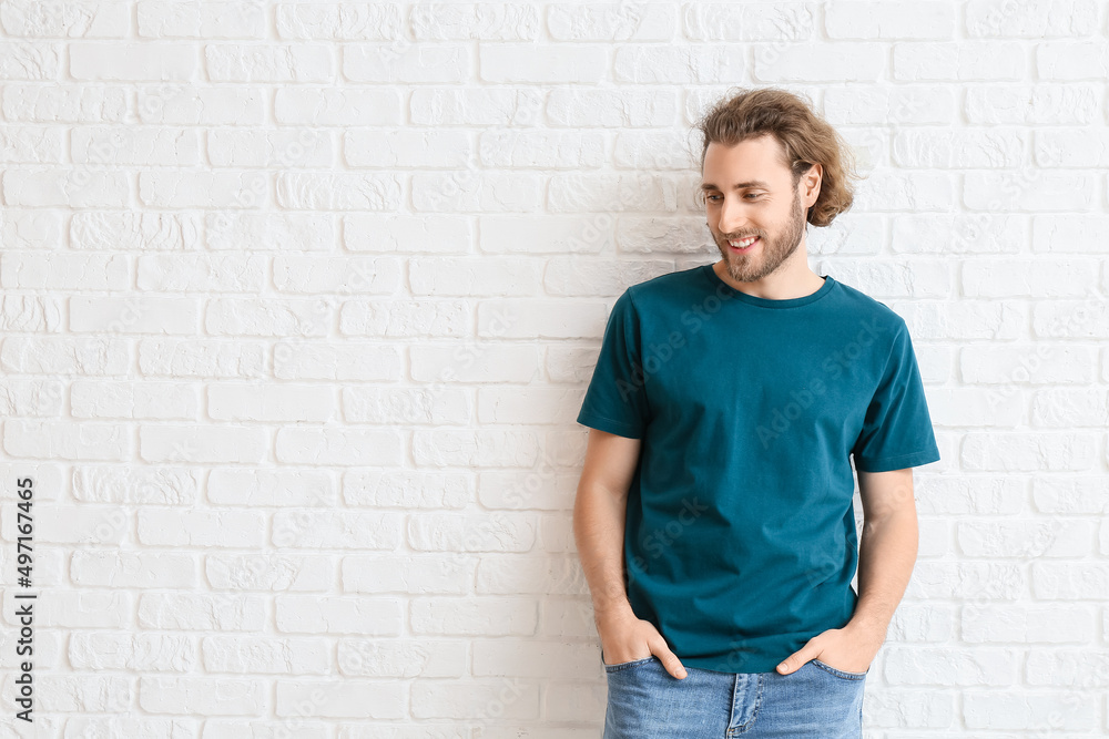 Handsome young man in t-shirt on white brick background Handsome young man in t-shirt on white brick background