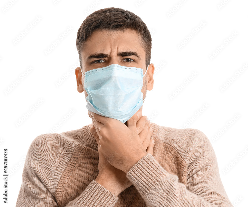Ill young man with sore throat wearing medical mask on white background Ill young man with sore throat wearing medical mask on white background