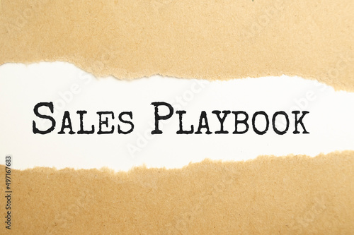 sales playbook text on torn paper on the white background with pen
