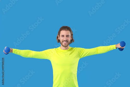 Sporty man with dumbbells o...