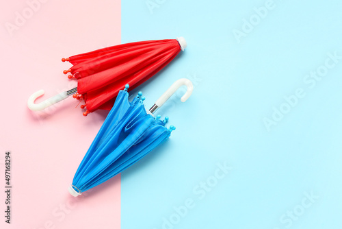 Red and blue umbrellas on color background