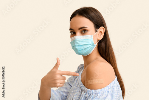 Young woman in mask pointin...