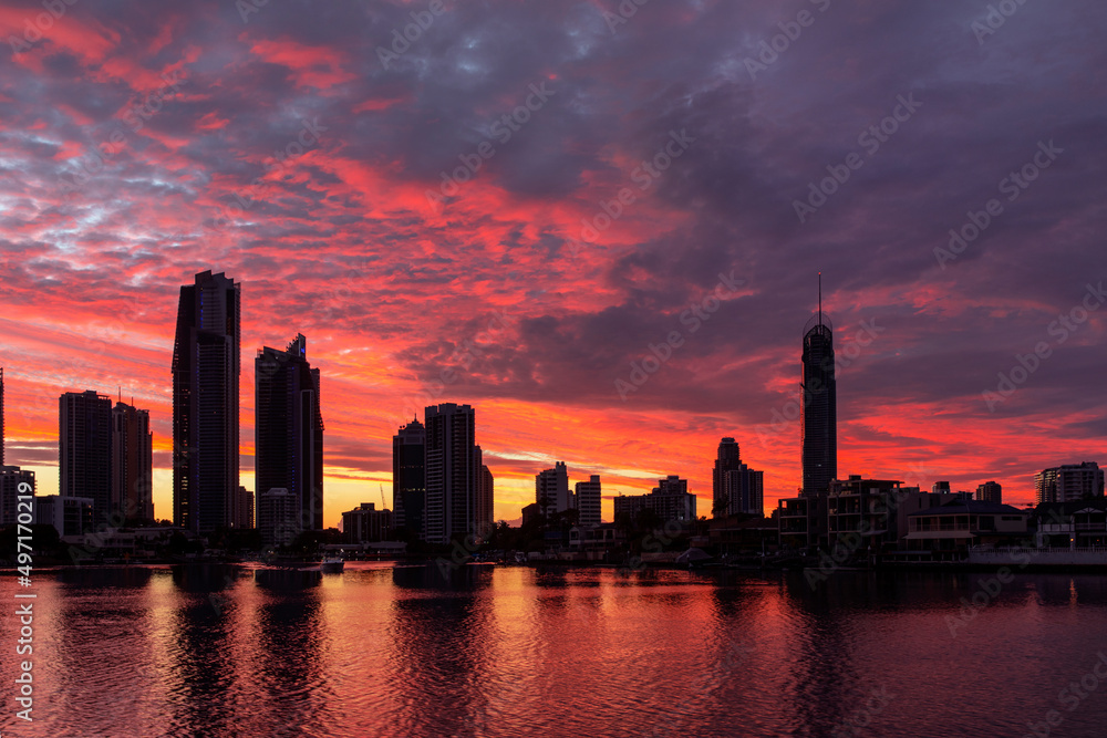 Orange sunrise clouds over Gold Coast city scape silhouette