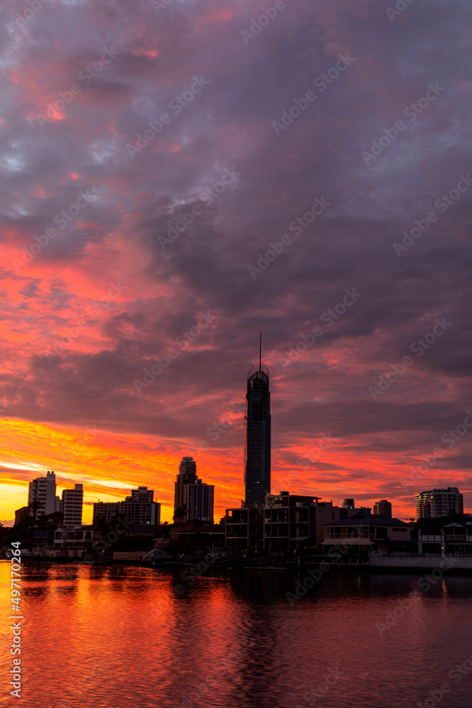 Orange sunrise clouds over Gold Coast city scape silhouette