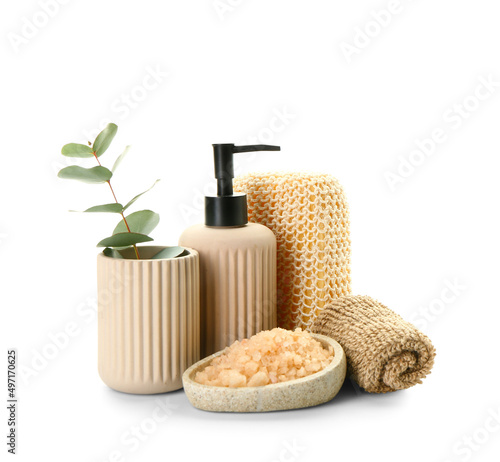 Bottle of cosmetic product, sea salt and bath sponges on white background