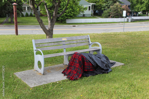 Homeless person beneath blankets at Delaney Strip Park in Anchorage, Alaska photo