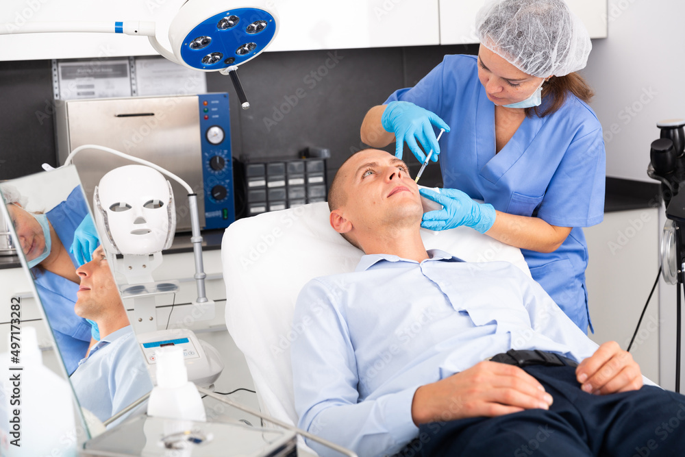Obraz premium Portrait of man getting face skin rejuvenation treatments at beautician office