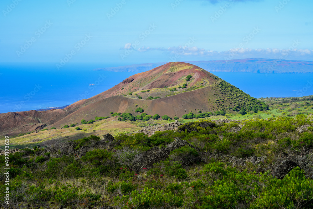 Volcanic crater on Piilani Highway in front of the Pacific Ocean with the West Maui Forest Reserve in the background