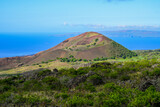 Volcanic crater on Piilani Highway in front of the Pacific Ocean with the West Maui Forest Reserve in the background