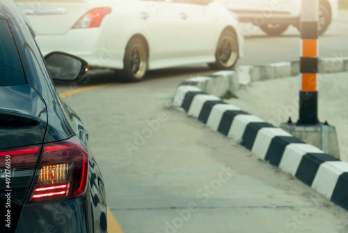 Rear side of cars on the road. Stop and open light brake with turn signal light. for U-turn on the asphalt road. With other cars on the front.