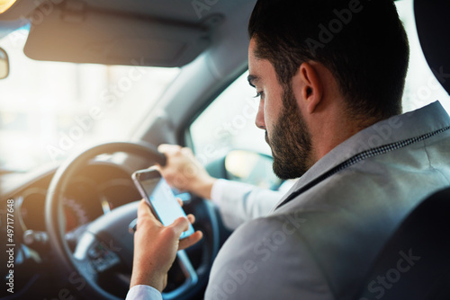 Distracted driving can increase the chance of a road accident. Cropped shot of a man using his phone while driving.