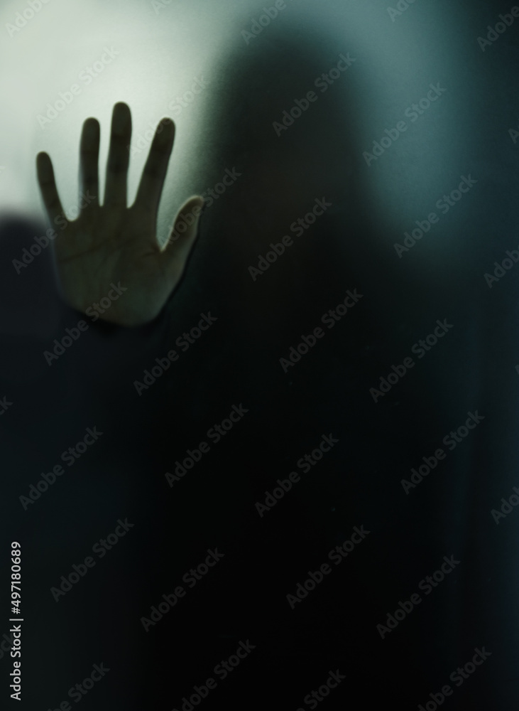 Isolated and doomed. Cropped shot of woman behind a glass wall during quarantine.