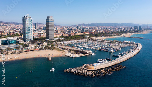 Scenic aerial view of famous Olympic Harbor Marina with docked white pleasure yachts on background of modern cityscape of Barcelona on Mediterranean coast on summer day, Spain.. © JackF