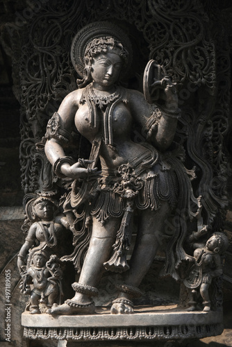 Stone Sculpture of Beautiful Female (Madanikas) with selective focus, 12th century Hindu temple, Ancient stone art and sculptures in each pillars, Chennakeshava Temple, Belur, Karnataka, India. photo
