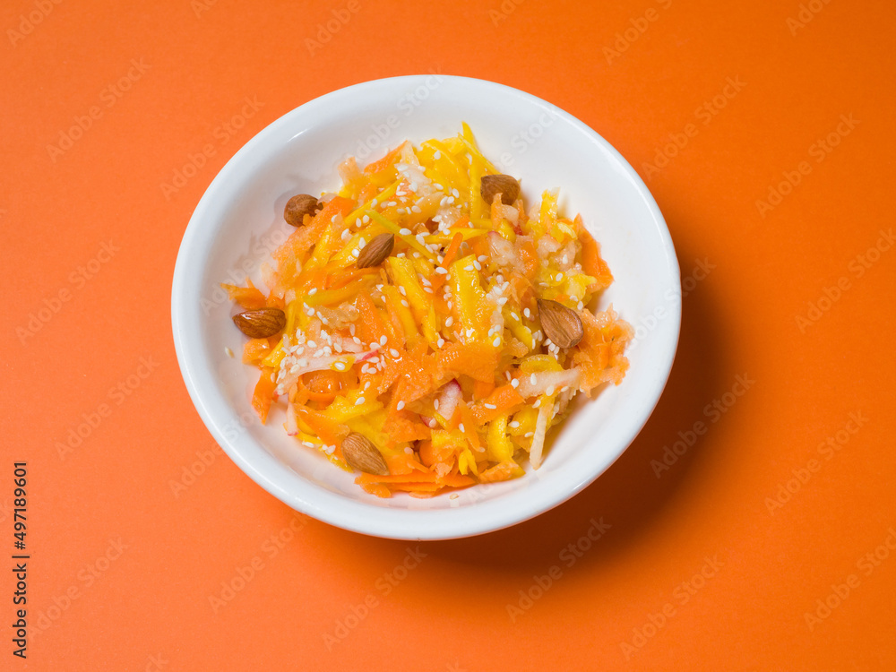 Pumpkin salad in a white plate on an orange background. Studio photography. View from above Pumpkin salad in a white plate on an orange background. Studio photography. View from above