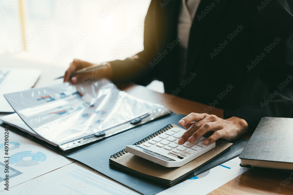 Young businessman using calculator and laptop computer is now finalizing sales this year to analyze sales growth by the world at work. Young businessman using calculator and laptop computer is now finalizing sales this year to analyze sales growth by the world at work.