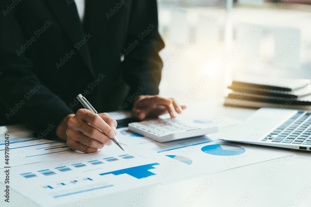 Fototapeta premium businessman working on desk office with using a calculator to calculate the numbers, finance accounting concept
