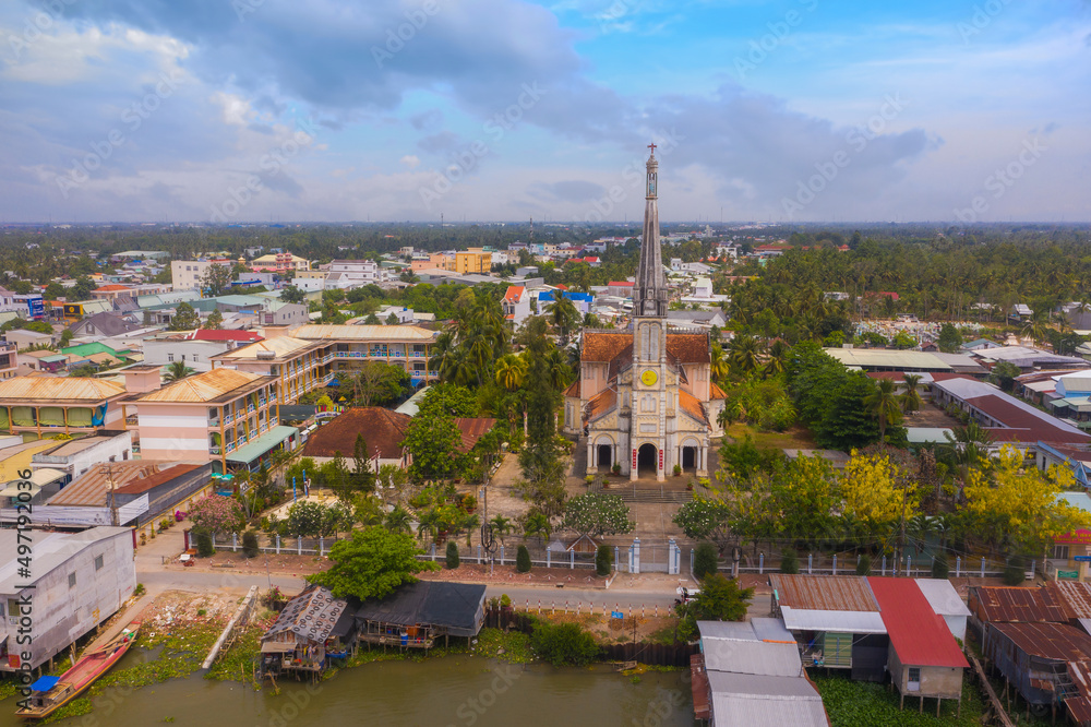 Aerial view of the famous Cai Be church in the Mekong Delta, Roman architectural style. In front is Cai Be floating market, Tien Giang, Vietnam.