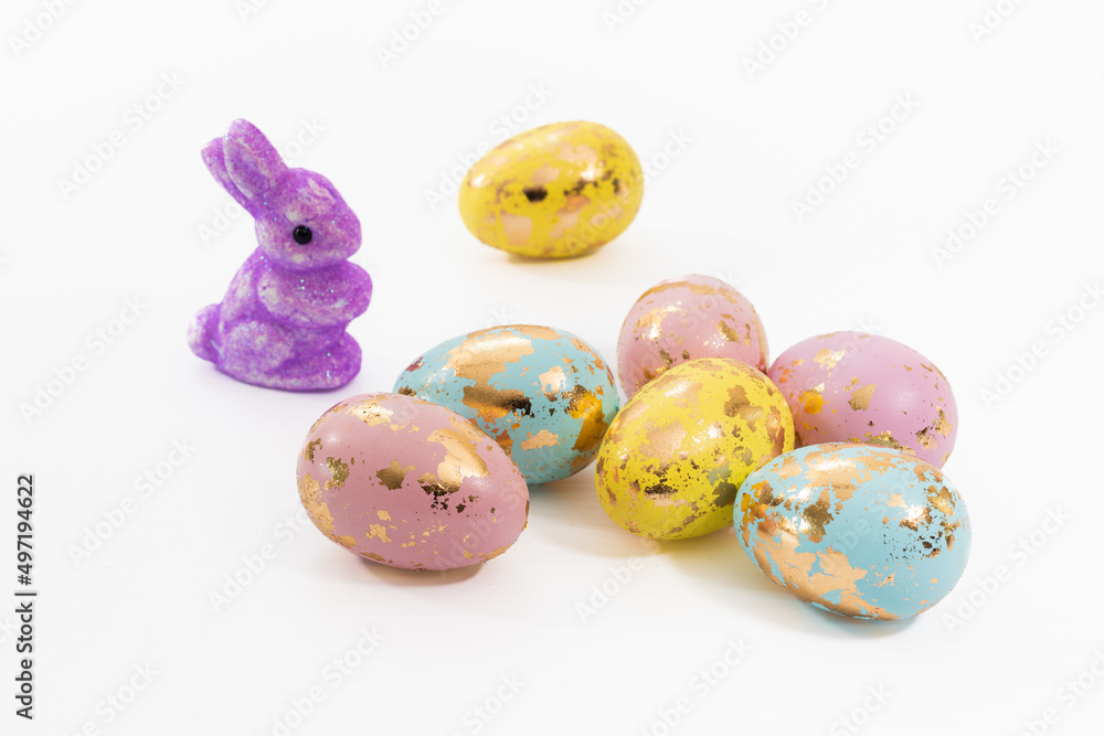 A cute decorative purple rabbit and colorful Easter eggs, a symbol of Easter, and the giving of Easter eggs.