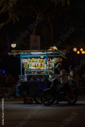 Traditional walking business selling dry squid on the street at night, food seller. Grilled dried squid in Mekong Delta, Vietnam. © CravenA
