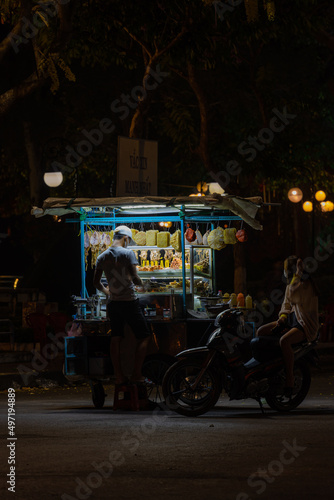 Traditional walking business selling dry squid on the street at night, food seller. Grilled dried squid in Mekong Delta, Vietnam. © CravenA