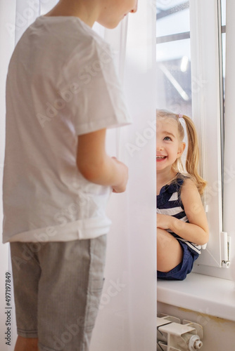 Children play hide and seek behind the curtain