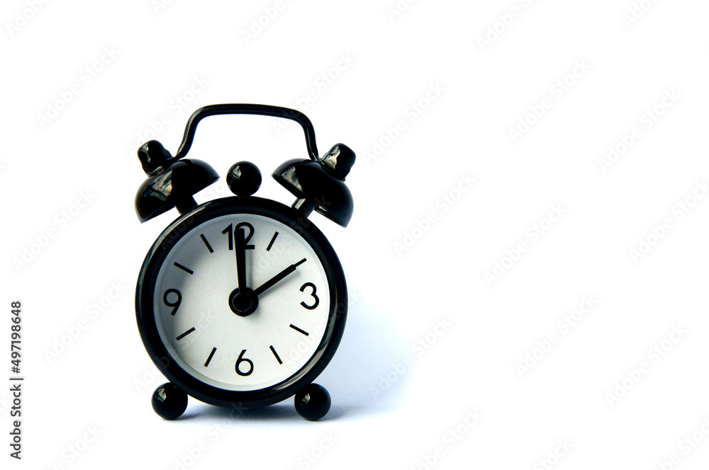 Black alarm clock isolated on white background. The clock set at 2 o'clock. Black alarm clock isolated on white background. The clock set at 2 o'clock.