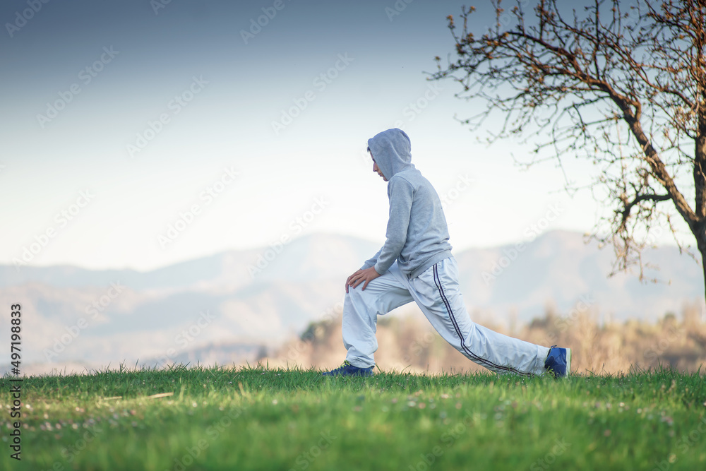 preparing for a sports competition, a young man performing exercises outdoor preparing for a sports competition, a young man performing exercises outdoor