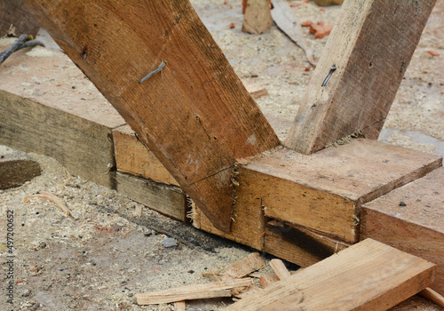 Roofing construction on the stage of roof framing. A close-up of trusses  rafters  roof beams joining together  attached to the top plate.