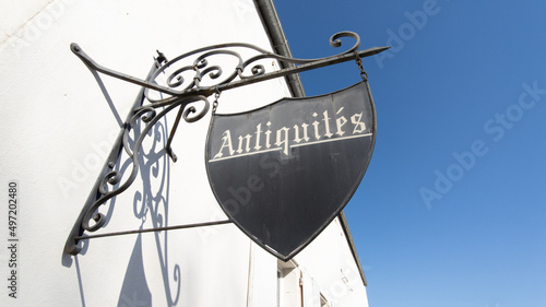 panel in facade street shop sign text in french antiquites translation means in english antiquities store photo