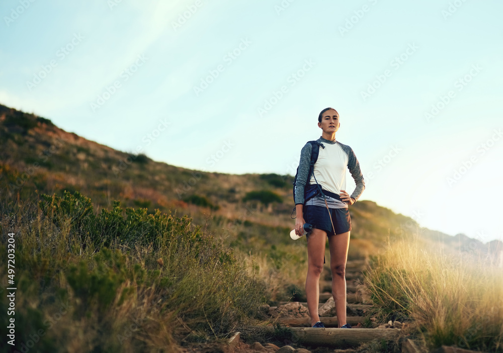 Im here to conquer the great outdoors. Portrait of a young woman out on a hike through the mountains. Im here to conquer the great outdoors. Portrait of a young woman out on a hike through the mountains.