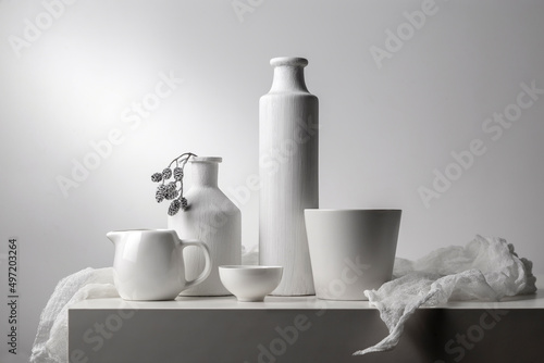 White still life with white dishes on a white background