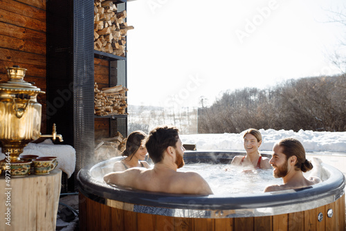 Friends of Caucasian appearance are resting in a country house, jacuzzi, nature and leisure, view from